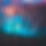 Blurred abstract background featuring vibrant shades of blue, teal, and pink with a soft, ethereal quality.