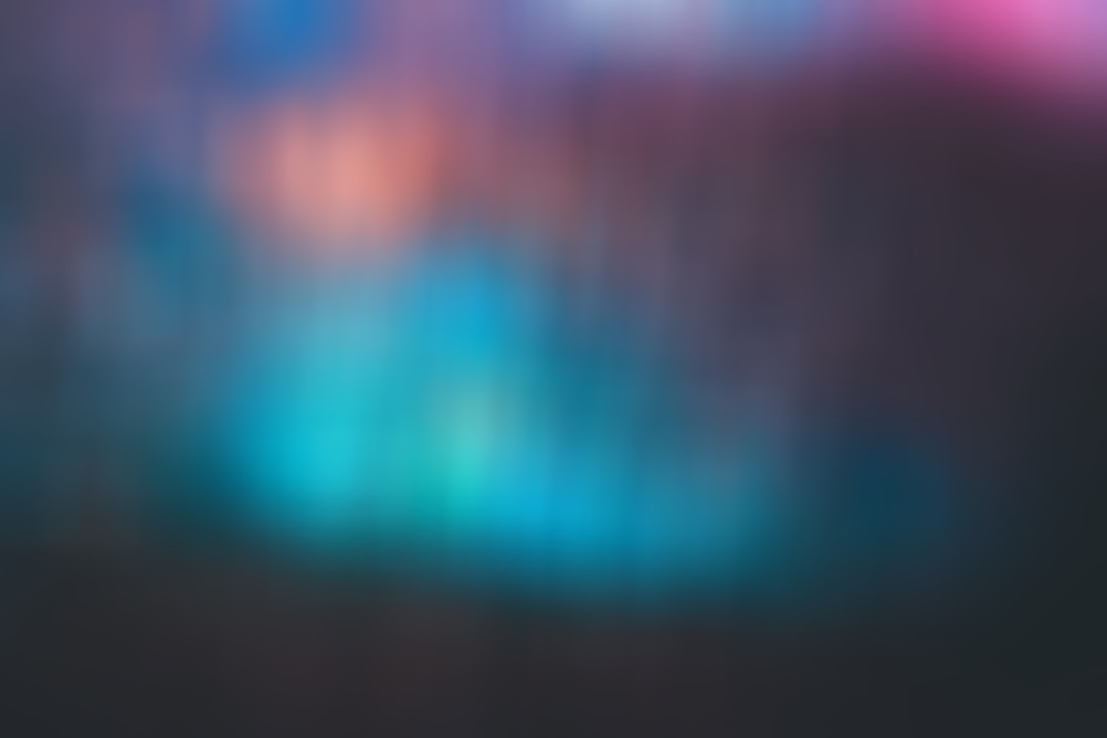 Blurred abstract background featuring vibrant shades of blue, teal, and pink with a soft, ethereal quality.