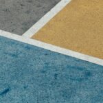 Gray, yellow, and blue textured surfaces intersect, with white lines marking the edges.