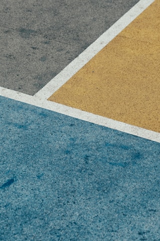 Gray, yellow, and blue textured surfaces intersect, with white lines marking the edges.