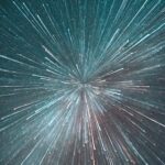 Starry night sky with streaks of light radiating outward, creating a sense of motion and depth in shades of blue and white.