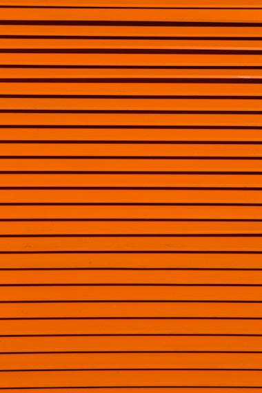 Horizontal lines of varying thickness in a bright orange color, creating a textured, striped pattern.